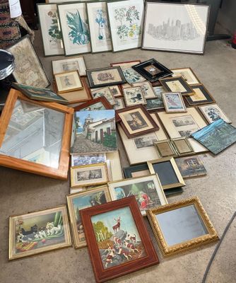 a lot of framed and unframed pictures on the floor