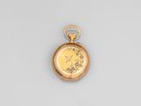 a close up of a gold pocket watch on a white surface