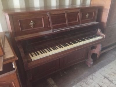 un piano dans un coin de la pièce, à côté d'une commode