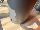 a water heater sitting on a wooden floor next to a trash can