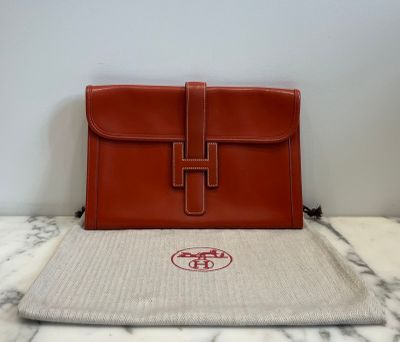 brown leather handbag sitting on top of a marble table