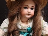 a doll that is wearing a hat and a dress