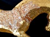 a gold horse statue on a black background