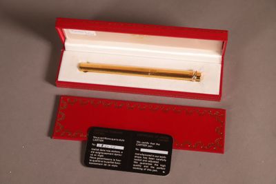 une boîte rouge contenant un stylo doré