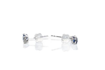 paire de boucles d'oreilles à clous en diamant bleu et blanc sur fond blanc