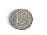 a close up of a silver coin on a white surface