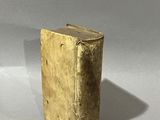 an old book sitting on top of a white table next to a cup of coffee