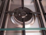 a close up of a gas stove with a glass shelf