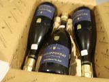 trois bouteilles de vin dans un coffret sur une table