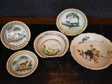 several plates and bowls are sitting on a wooden table