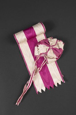 pink and white striped ribbon with a bow on a black background