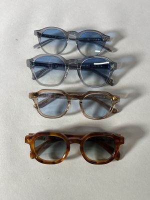 three pairs of glasses sitting next to each other on a white surface