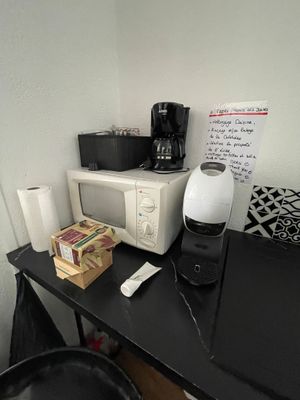 a microwave and a coffee maker sitting on a desk