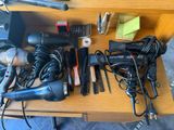 many hair dryers and other hair accessories on a table