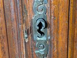a close up of a door handle on a wooden door
