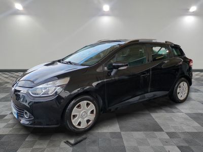 a black car is parked on a checkered floor in a garage