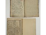 two old books with chinese writing on them, one open and the other closed