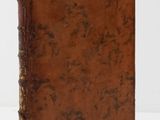 an old book sitting on top of a white surface