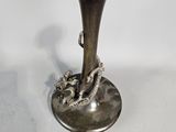 a silver vase with a dragon on it sitting on a table