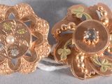 une paire de broches en forme de fleur, de couleur dorée, ornées de cristaux