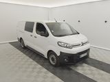 La camionnette blanche est garée dans une pièce propre au sol carrelé.