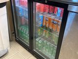 des bouteilles de soda et de boissons gazeuses sont rangées dans le réfrigérateur d'une cuisine
