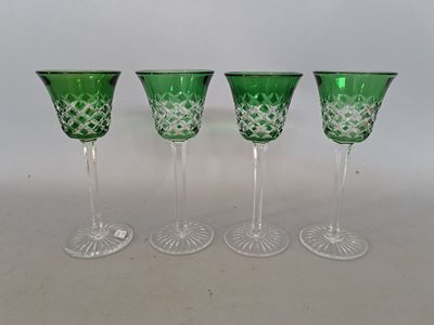 four green glass goblets sitting next to each other on a table