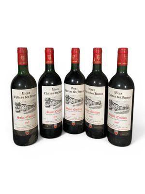 six bouteilles de vin sont alignées sur une surface blanche