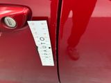 a sticker on the door handle of a red car