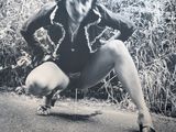 photographie en noir et blanc d'une femme sur un skateboard au milieu de la route
