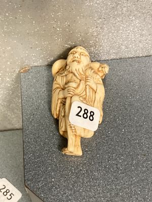 une petite figurine sculptée représentant un homme tenant un oiseau