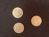 three different types of coins on a black surface
