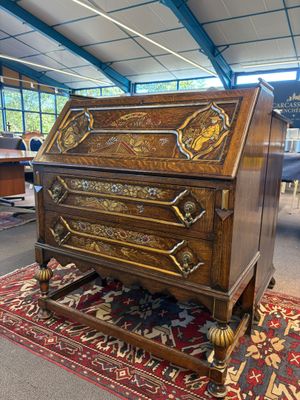 un vieux bureau en bois orné de sculptures élaborées, dans une pièce