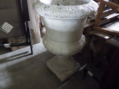 a large white vase sitting on a stand in a room