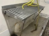 a metal bench with a yellow hose in a room