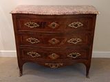 a marble top chest of drawers in the corner of a room