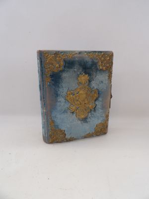un petit livre bleu orné d'un motif doré