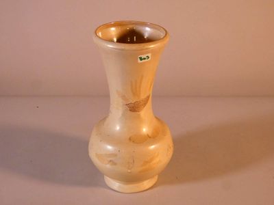 un vase blanc bordé d'or posé sur une table