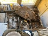 a pile of dirty dishes on the stove in the kitchen