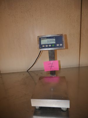 une image représentant une balance posée sur une table, avec une note accrochée dessus