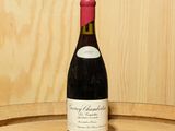 une bouteille de vin posée sur un tonneau