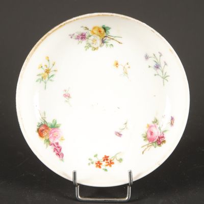 a white plate with flowers on it on a stand