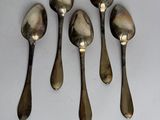 six spoons are lined up in a row on a white surface