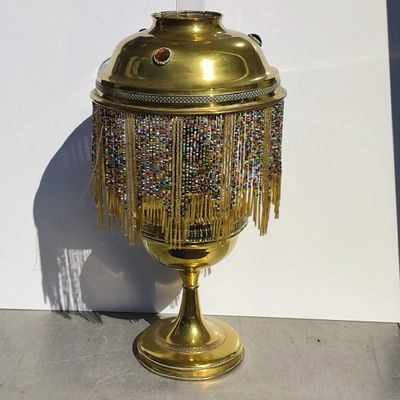 a gold urn with beads and fringes on it