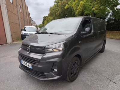 La camionnette est garée sur le bord de la route, devant un immeuble.