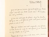 a handwritten letter on a piece of paper on a table