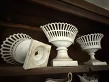 several white vases and a clock on a shelf in a room