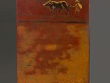 an orange and yellow painting on a wooden stand against a gray background
