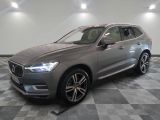 un SUV Volvo gris garé dans un garage au sol carrelé