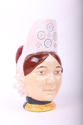 une tête de femme en céramique avec un chapeau